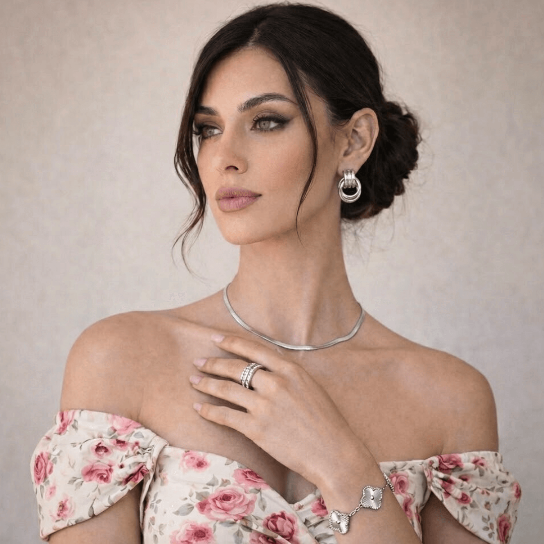 Female model wearing silver knotted stud, talia snake chain silver, layla double layer eternity band, Aura flower bracelet bracelet silver