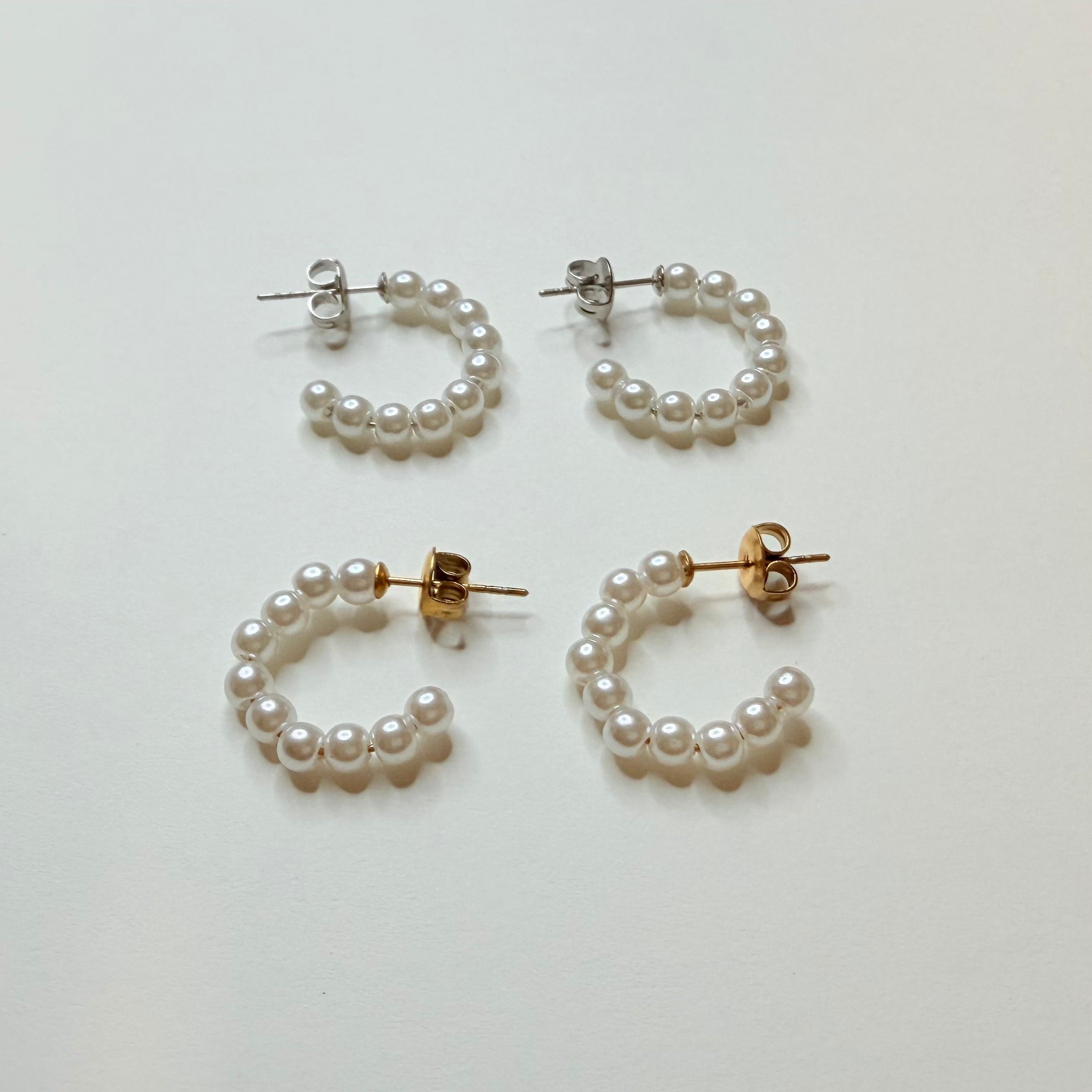 Set of pearl hoop earrings on a light gray background