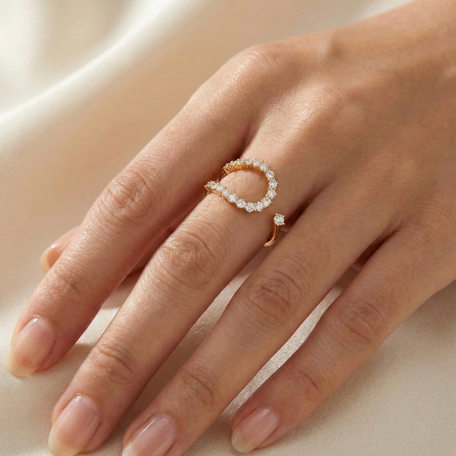 Gold open ring with white zircon stones on a models hand