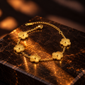 A gold bracelet with five textured flower-shaped links, displayed on a dark brown marble block with warm, dramatic lighting.