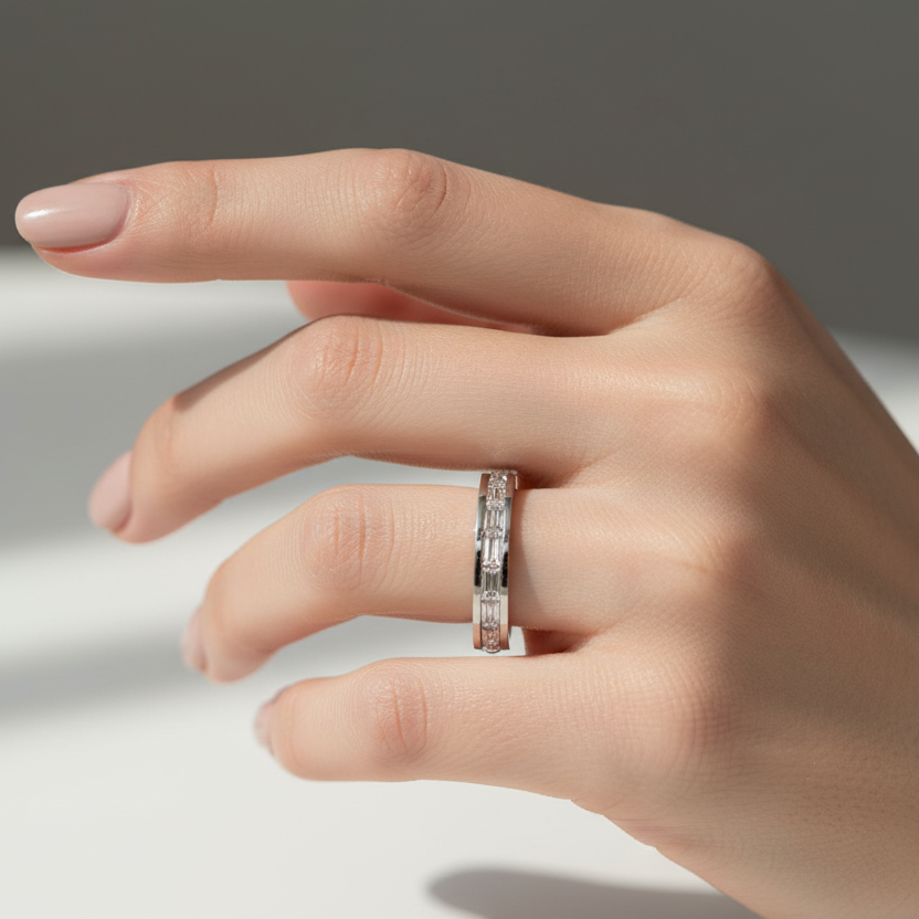 Hand wearing a diamond ring on a neutral background