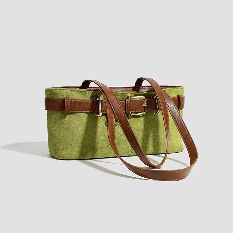 Green bag with brown leather straps on a light gray background