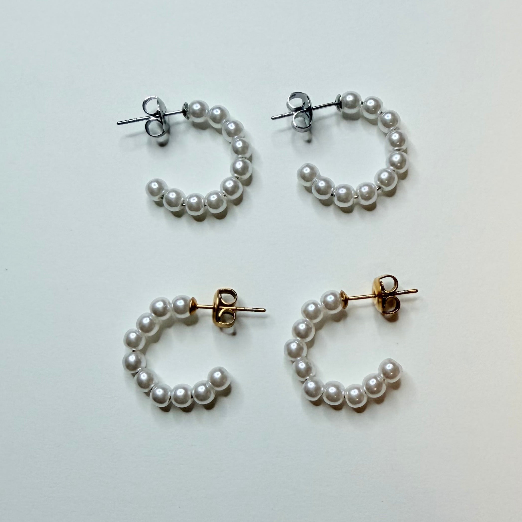 Set of pearl hoop earrings on a light gray background